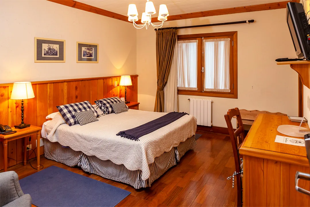 Quarto com almofadas xadrez azul e lustre branco