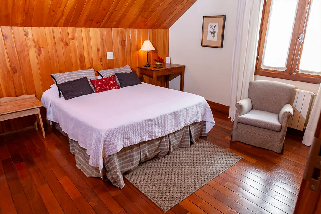 Quarto aconchegante com poltrona e cama de casal