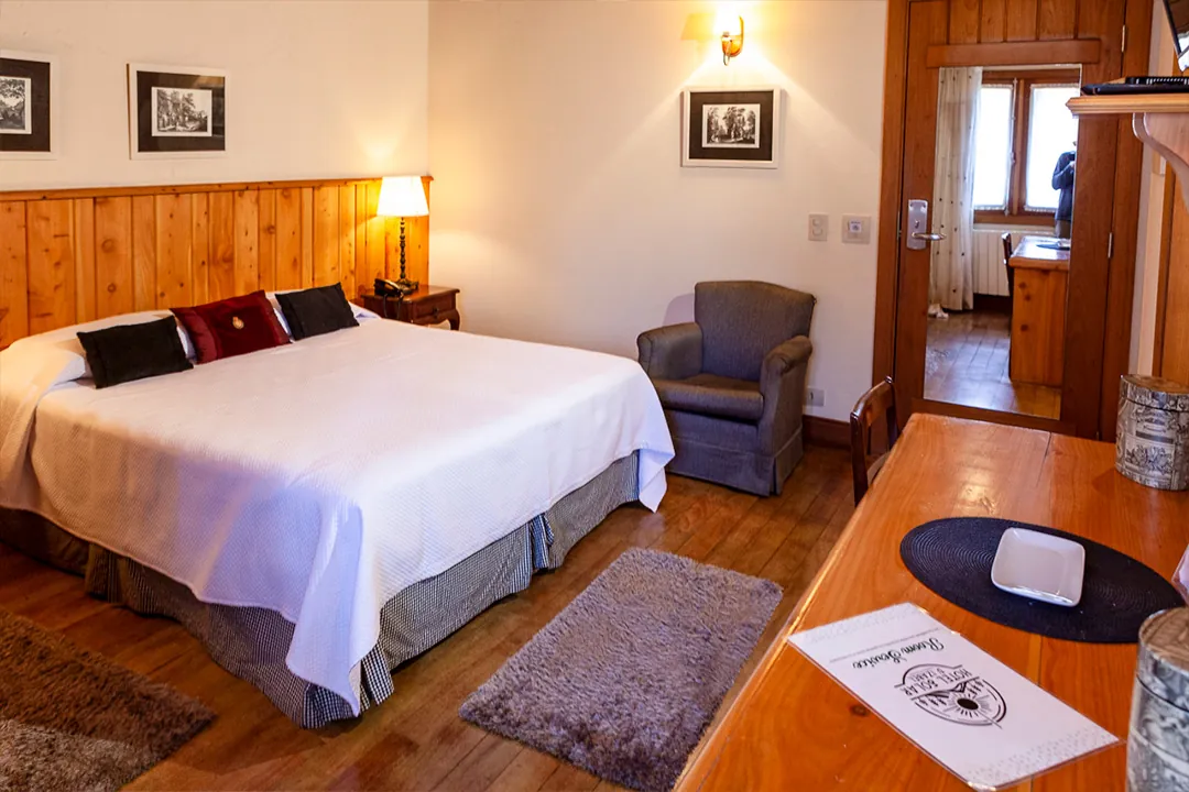 Quarto com janela que dá para a vegetação da serra